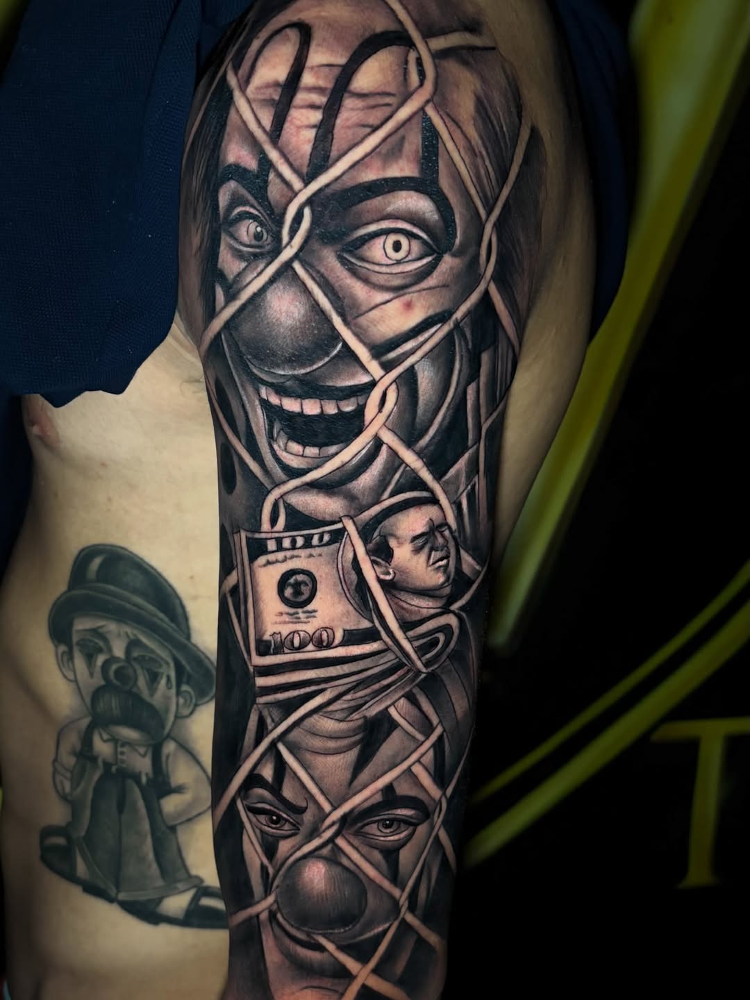 Composição tatuada de máscara sorridente, notas e faixas com sombras intensas